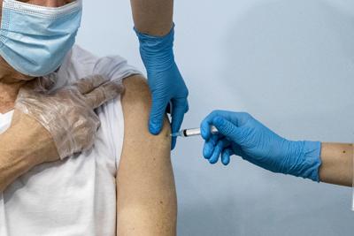 ARCHIVO - En esta foto de archivo del 20 de enero de 2021, un paciente recibe la vacuna cintra el COVID-19 de Sputnik V en Moscú. Las autoridades de cuatro regiones rusas decretaron esta semana la obligación de vacunar a trabajadores de ciertos sectores de la economía. (AP Foto/Pavel Golovkin, File)