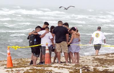 Varias personas se unen para orar el viernes 25 de junio de 2021 en la playa frente al sitio donde se colapsó el edificio Champlain Towers South Condo, en Surfside, Florida. (Pedro Portal/Miami Herald vía AP)