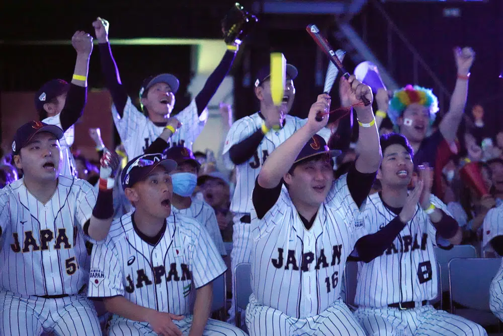 Aficionados japoneses reaccionan al observar la transmisión del juego entre Japón y México en las semifinales del Clásico Mundial de béisbol, el martes 21 de marzo de 2023, en Tokio. (AP Foto/Eugene Hoshiko)