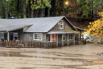 Aguas del Lago Madrone desbordado pasan frente a una casa en la carretera Oro Quincy, el domingo 24 de octubre de 2021, en el condado Butte de California. (AP Foto/Noah Berger)