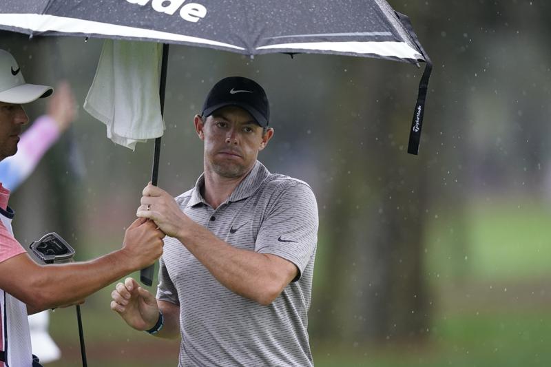 Rory McIlroy, of Northern Ireland, tries to stay dry on ninth green during the first round of play in The Players Championship golf tournament Friday, March 11, 2022, in Ponte Vedra Beach, Fla. (AP Photo/Gerald Herbert)
