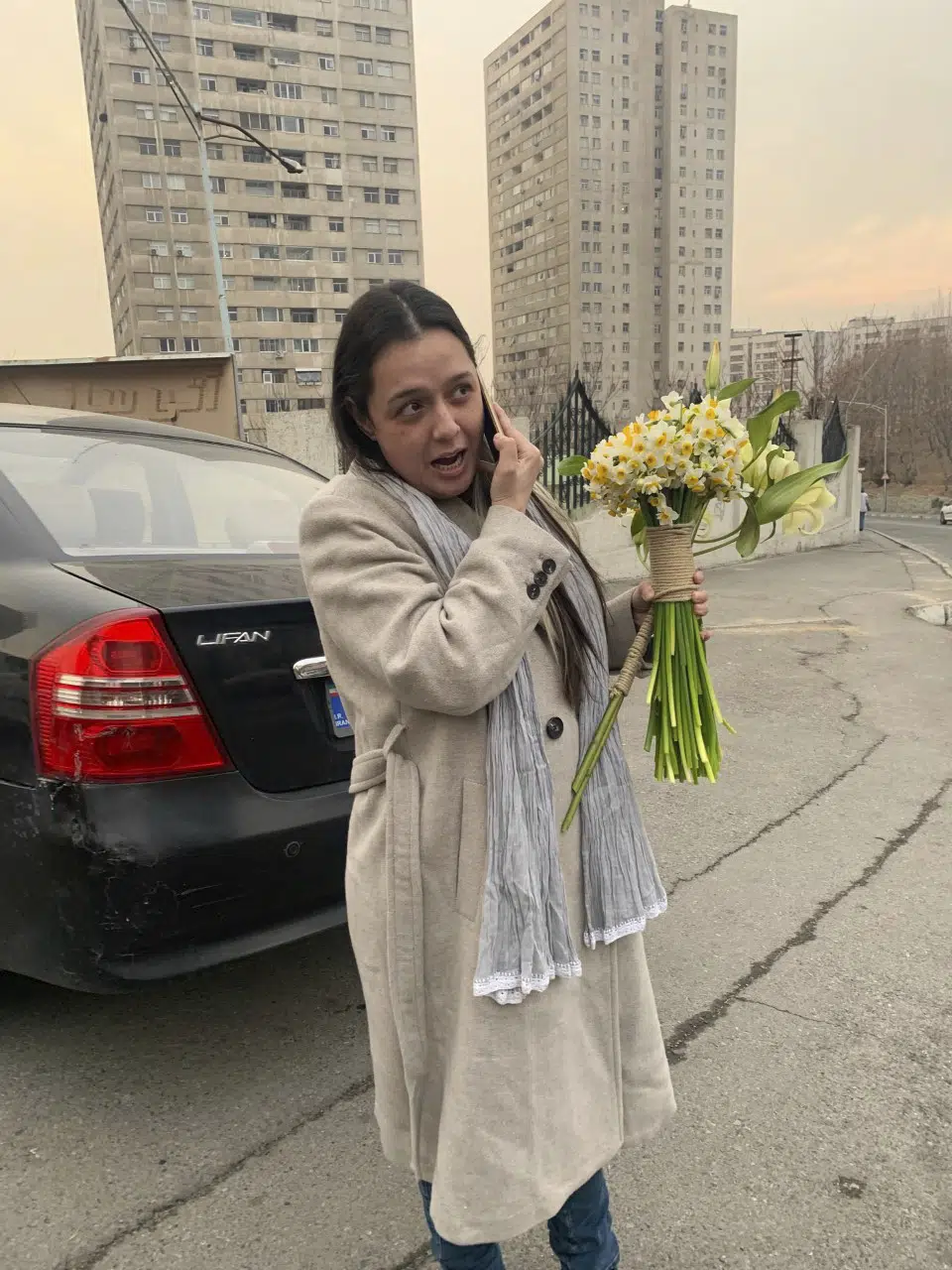 Iranian prominent actress Taraneh Alidoosti speaks on a cellphone as she holds bunches of flowers after being released from Evin prison in Tehran, Iran, Wednesday, Jan. 4, 2023. Iran released Alidoosti, a prominent actress from an Oscar-winning film, nearly three weeks after she was jailed for criticizing a crackdown on anti-government protests. (Gisoo Faghfouri, Sharghdaily, via AP)