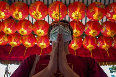 Una persona sostiene una vara de incienso mientras pide buena fortuna en la víspera del Año Nuevo lunar chino, en el templo Tai Hong Kong de Bangkok, Tailandia, el 31 de enero de 2022. Según el calendario lunar, el año nuevo comienza el 1 de febrero. (AP Foto/Sakchai Lalit)