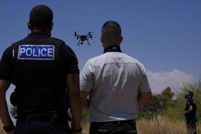 Agentes de la policía británica controlan un dron con cámaras desde la base militar británica de Dhekelia, entre el sur de Chipre, de influencia griega, y el norte, de influencia turca, en Chipre, el martes 6 de julio de 2021. (AP Foto/Petros Karadjias)
