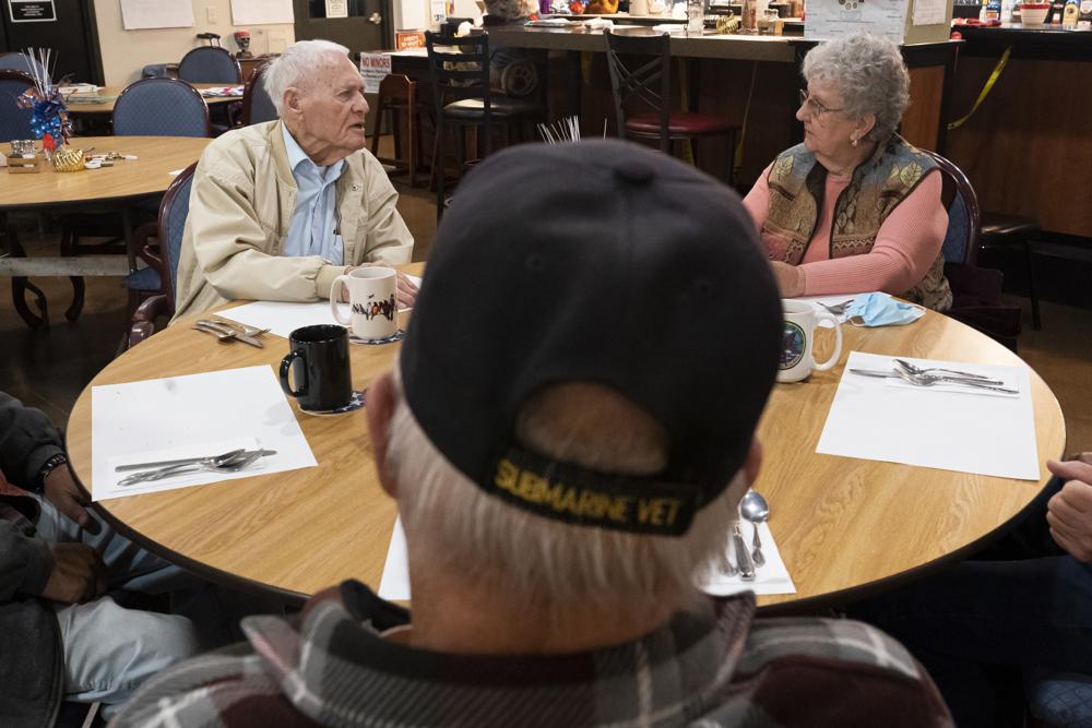 Der Überlebende von Pearl Harbor und Navy-Veteran des Zweiten Weltkriegs, David Russell, 101, links, spricht mit Karen Wilson, rechts, und anderen Veteranen, während er am Montag, den 22. November 2021, in Albany, Erz, im American Legion Post 10 frühstückt. ( AP-Foto/Nathan Howard)