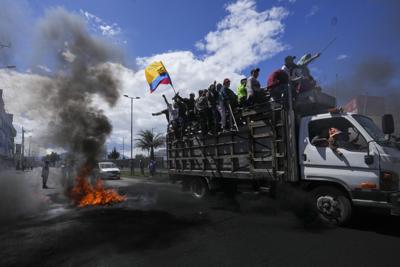 Manifestantes antigubernamentales pasan frente a una barricada en llamas durante protestas contra el gobierno del presidente Guillermo Lasso convocadas principalmente por organizaciones indígenas, el jueves 16 de junio de 2022, en Quito, Ecuador. (Foto AP/Dolores Ochoa)
