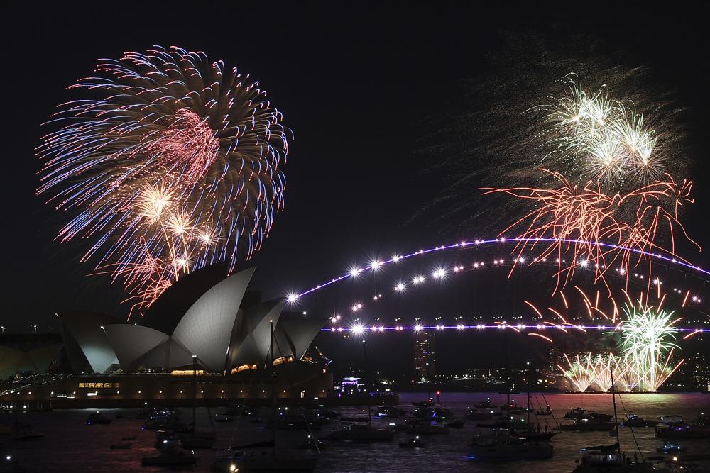 Los fuegos artificiales explotan sobre la Ópera de Sídney y el Puente del Puerto cuando comienzan las celebraciones de Nochevieja en Sídney, el viernes 31 de diciembre de 2021 (Dean Lewins / AAP Image via AP).