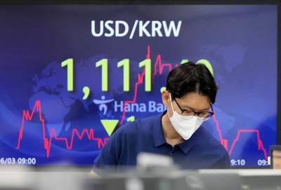 Una persona frente a una cartelera financiera en Seúl el 3 de junio del 2021.   (AP Photo/Lee Jin-man)
