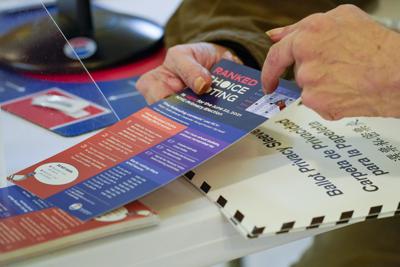 Un trabajador de un centro electoral explica el nuevo sistema de voto múltiple a una persona que quería votar por adelantado en las elecciones para alcalde de Nueva York el 14 de junio del 2021 en la Iglesia de San Antonio de Padua en el barrio de Soho. (AP Photo/Mary Altaffer)