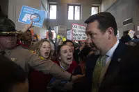 Addie Brue, 16 and Madeline Lederman, 17, shout "do something," with other protesters as Rep. Jeremy Faison, R-Cosby, Chairman of the House Republican Caucus, walks towards the House chamber doors at the State Capitol Building in Nashville , Tenn., Thursday, March 30, 2023. (Nicole Hester/The Tennessean via AP)