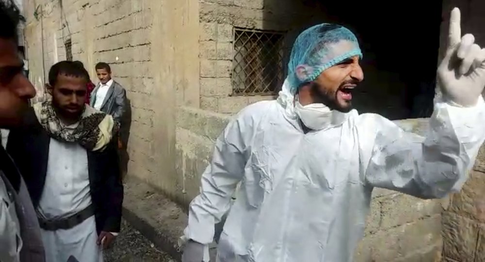 This May 2020 frame grab from video provided by a Yemeni Community activist, shows an activist wearing protective gear arguing with a person in the neighborhood, while collecting the body of a COVID-19 victim, after medics declined to take the body, in the Houthi-controlled city of Ibb, Yemen. An investigation by The Associated Press found that the coronavirus is taking a deadly toll on the war weary population of Yemen. The situation is exacerbated in the Houthi-controlled north where the rebels have suppressed information about the virus, severely punished those who speak out, enforced little mitigation measures, and promoted conspiracies and claims by the Houthi minister of health that scientists are working on developing a cure for covid-19 to present to the world. (Courtesy of a Yemeni Community Activist via AP)