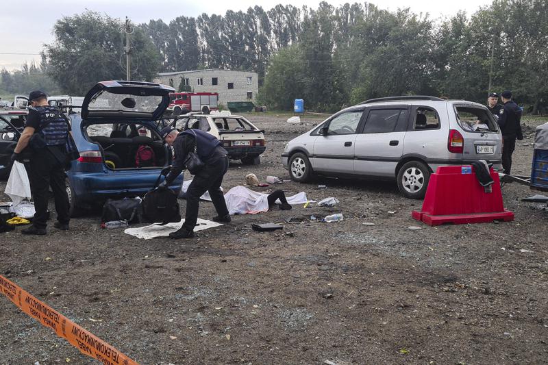 Police officers check the bags of killed civilians after a Russian rocket attack in Zaporizhzhia, Ukraine, Friday, Sept. 30, 2022. A Russian strike on the Ukrainian city of Zaporizhzhia killed at least 23 people and wounded dozens, an official said Friday, just hours before Moscow planned to annex more of Ukraine in an escalation of the seven-month war. (AP Photo/Viacheslav Tverdokhlib)