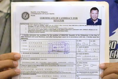 Un representante del presidente de Filipinas, Rodrigo Duterte, sostiene su certificado de candidato a senador en la Comisión de Elecciones de Manila, Filipinas, el lunes 15 de noviembre de 2021. (AP Foto/Aaron Favila)