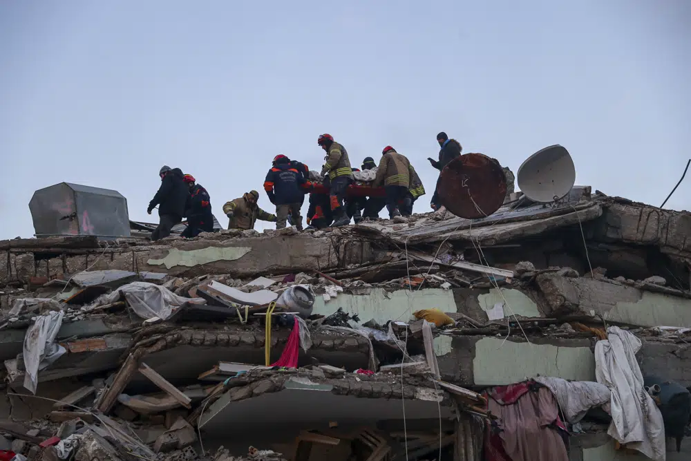 Rescatistas turcos tratan de sacar a Ergin Guzeloglan, de 36 años, de entre los escombros de un edificio caído cinco días después de un devastador terremoto, en Hatay, en el sur de Turquía, el 11 de febrero de 2023. (AP Foto/Can Ozer)