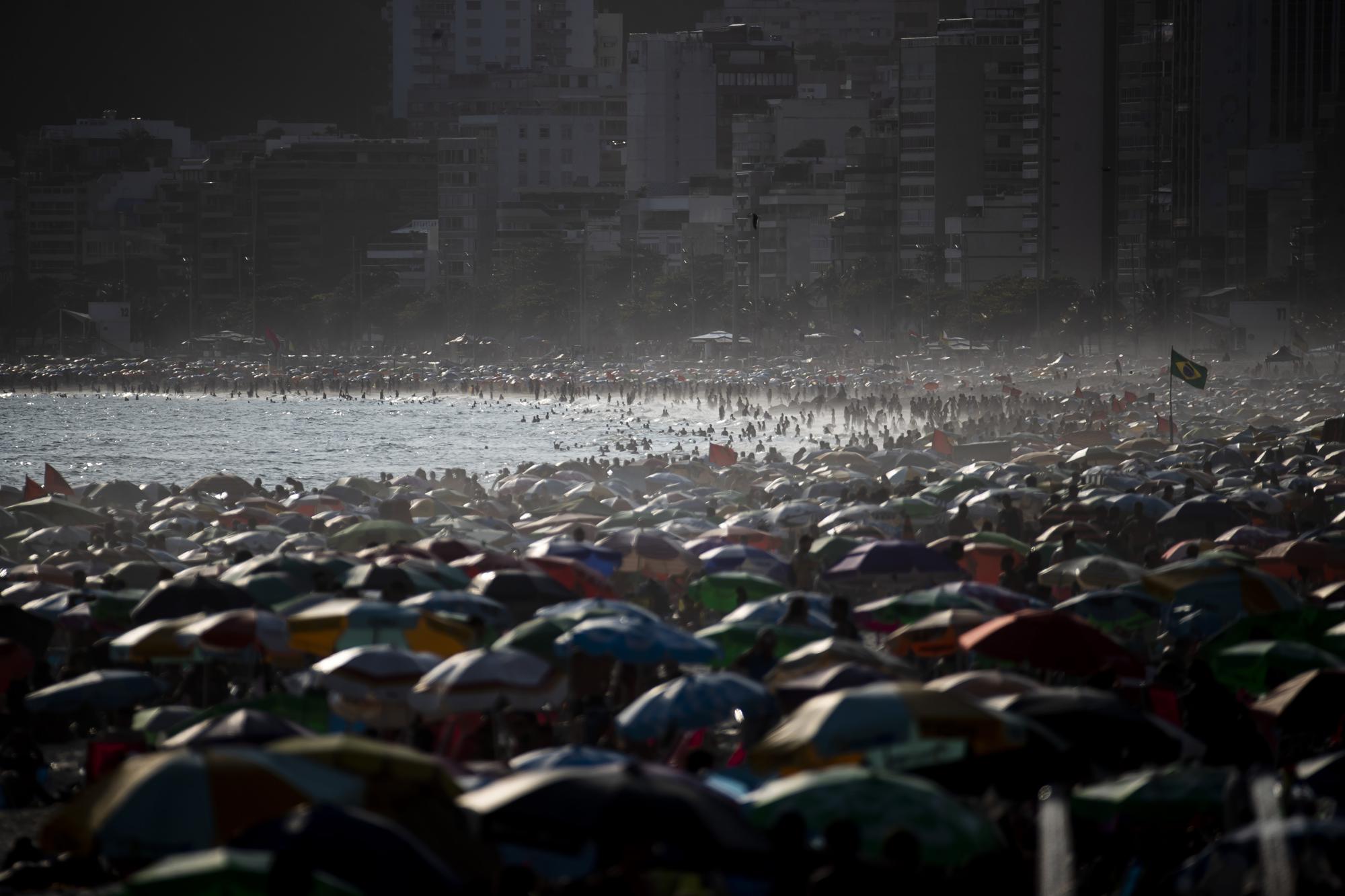 People enjoy the Ipanema beach, in Rio de Janeiro, Brazil, Sunday, Nov.13, 2022. The world's population is projected to hit an estimated 8 billion people on Tuesday, Nov. 15, according to a United Nations projection. (AP Photo/Bruna Prado)
