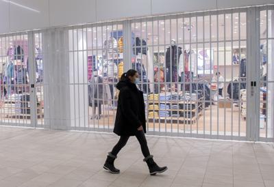 Una mujer camina frente a una tienda cerrada en un centro comercia, el domingo 2 de enero de 2022, en Montreal. (Graham Hughes /The Canadian Press via AP)