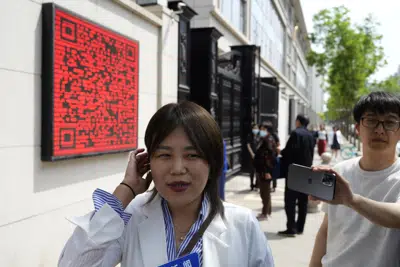 Teresa Xu speaks to journalists before her appeal hearing in Beijing, Tuesday, May 9, 2023. The unmarried Chinese woman on Tuesday began her final appeal of a hospital's denial of access to freeze her eggs five years ago in a landmark case of female reproductive rights in the country. (AP Photo/Ng Han Guan)