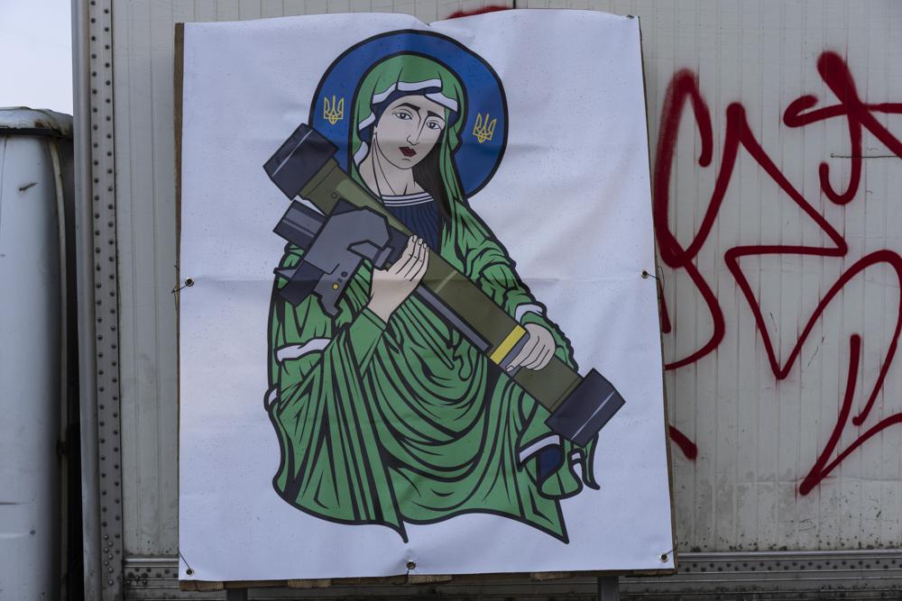 A banner with the image known as "Saint Javelin" depicting a saint holding a Javelin, an American-made portable anti-tank missile system, is displayed in a check point in Kyiv, Ukraine, Friday, March 25, 2022. (AP Photo/ (AP Photo/Rodrigo Abd)