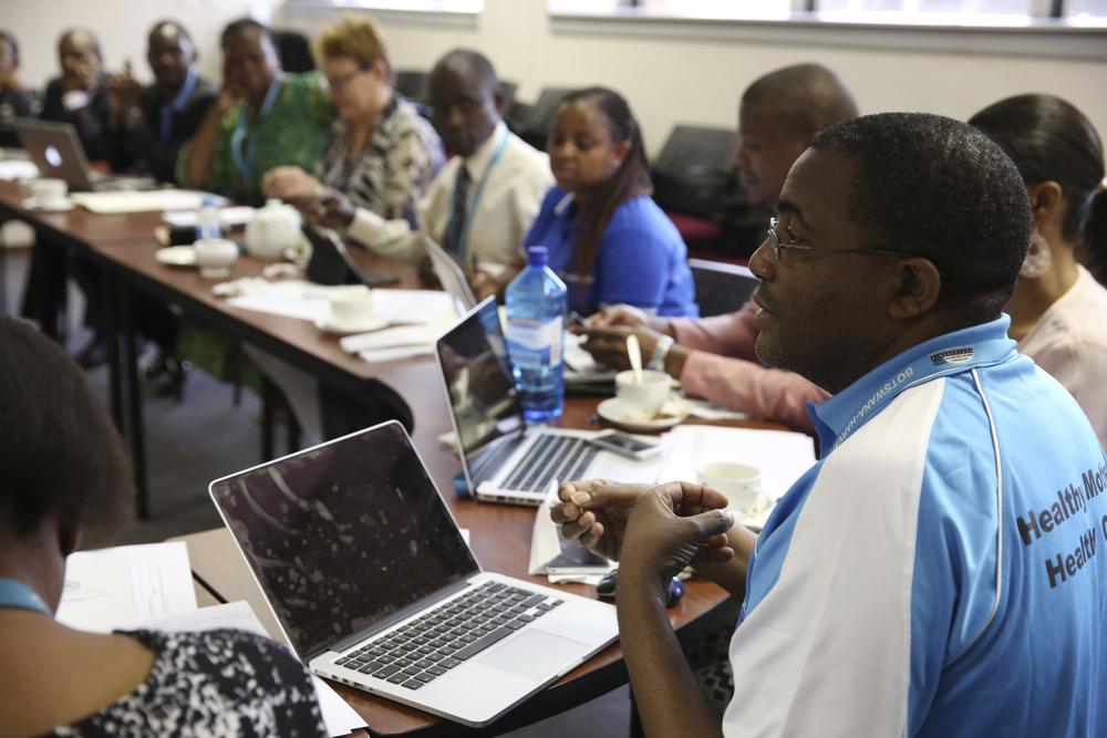 In this September 2015 photo provided by Botswana-Harvard Partnership, Dr. Sikhulile Moyo, virologist at the Botswana Harvard AIDS Institute Partnership, speaks at a study team meeting for the Botswana Combination Prevention Project (BCPP) in Botswana. Moyo, who may well have discovered the omicron variant, says he's been through a “rollercoaster of emotions” — the pride of accomplishment followed by dismay over the travel bans and flight restrictions immediately slapped on southern African countries. (Dominic Chavez/Botswana-Harvard Partnership via AP)