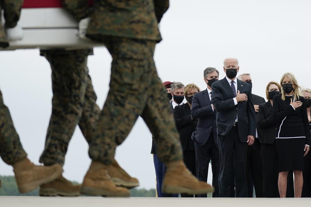 President Joe Biden and first lady Jill Biden watch as a carry team moves a transfer case containing the remains of Marine Corps Lance Cpl. Kareem M. Nikoui, 20, of Norco, Calif., during a casualty return Sunday, Aug. 29, 2021, at Dover Air Force Base, Del. According to the Department of Defense, Nikoui died in an attack at Afghanistan's Kabul airport, along with 12 other U.S. service members. (AP Photo/Carolyn Kaster)