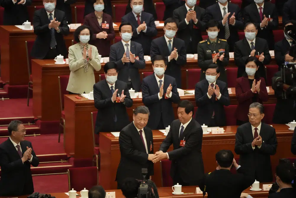 Chinese President Xi Jinping is congratulated by Li Zhanshu after he is unanimously elected as President during a session of China's National People's Congress (NPC) at the Great Hall of the People in Beijing, Friday, March 10, 2023. Chinese leader Xi Jinping was awarded a third five-year term as president on Friday, putting him on track to stay in power for life. (AP Photo/Mark Schiefelbein)