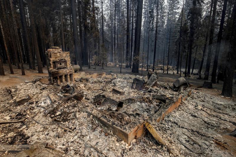 The remnants of a foundation is all this left after a property was destroyed by the Caldor Fire in Grizzly Flats, Calif., on Tuesday, Aug. 17, 2021. (AP Photo/Ethan Swope)