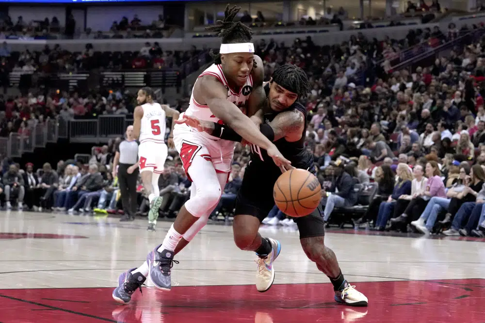 Chicago Bulls' Ayo Dosunmu, left, and Orlando Magic's Gary Harris battle for the ball during the first half of an NBA basketball game Monday, Feb. 13, 2023, in Chicago. (AP Photo/Charles Rex Arbogast)