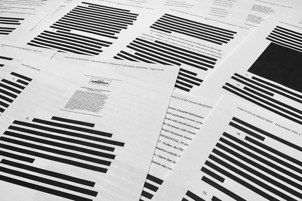 Pages from the affidavit by the FBI in support of obtaining a search warrant for former President Donald Trump's Mar-a-Lago estate are photographed Friday, Aug. 26, 2022. U.S. Magistrate Judge Bruce Reinhart ordered the Justice Department to make public a redacted version of the affidavit it relied on when federal agents searched Trump's estate to look for classified documents. (AP Photo/Jon Elswick)