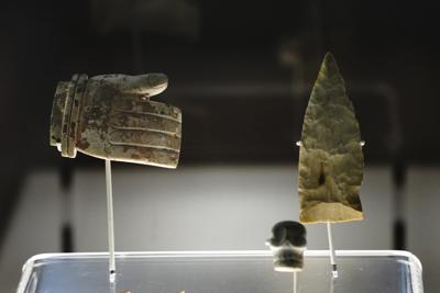 Una mano tallada y una punta de flecha son mostradas en la exposición "La Grandeza de México" el viernes 1 de octubre de 2021, en la que se exponen cientos de piezas prehispánicas en el Museo Nacional de Antropología, en la Ciudad de México. (AP Foto/Marco Ugarte)
