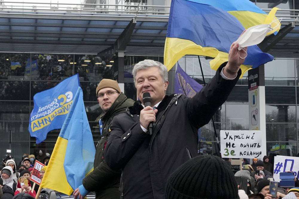 Former Ukrainian President Petro Poroshenko gestures while speaking to his supporters upon his arrival at Zhuliany International Airport outside Kyiv, Ukraine, Monday, Jan. 17, 2022. Poroshenko has returned to Ukraine to face court on treason charges he believes are politically motivated. At the Kyiv airport, where he arrived on a flight from Warsaw on Monday morning, Poroshenko was greeted by several thousand supporters. (AP Photo/Efrem Lukatsky)