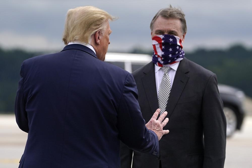 FILE - President Donald Trump greets then-Sen. David Perdue, R-Ga., as he arrives at Dobbins Air Reserve Base for a campaign event Sept. 25, 2020, in Atlanta. Trump wants to use November's midterm elections to solidify his continued dominance of the national Republican Party. Few places are more central to that effort than Georgia. Enraged that Republican Gov. Brian Kemp didn't advance lies that the state's free and fair presidential election was stolen, Trump recruited former Sen. David Perdue to run against him in the May 24 primary. (AP Photo/Evan Vucci, File)