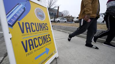 Un letrero en español e inglés indica el rumbo a una clínica de vacunación contra COVID-19 en Lawrence, Massachusetts, el miércoles 29 de diciembre de 2021. (AP Foto/Charles Krupa)