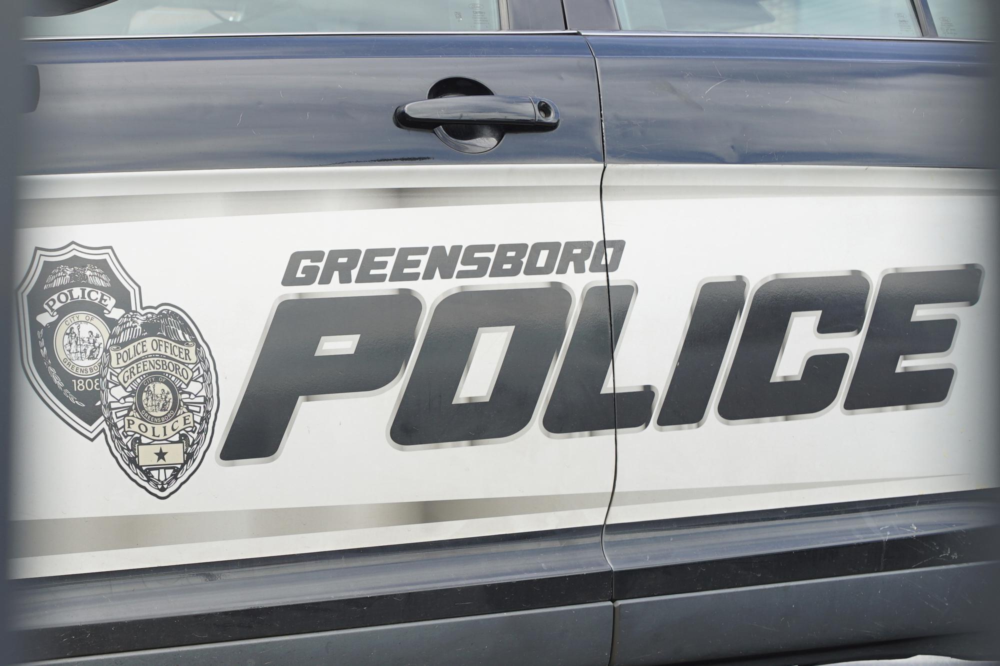 A cruiser sits in a parking lot outside police headquarters in Greensboro, N.C.,