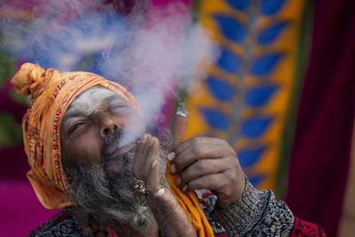 Un santón hindú fuma marihuana durante el festival Mahashivarati en el templo Pashupatinath en Katmandí, Nepal, martes 1 de marzo de 2022. (AP Foto/Niranjan Shreshta)