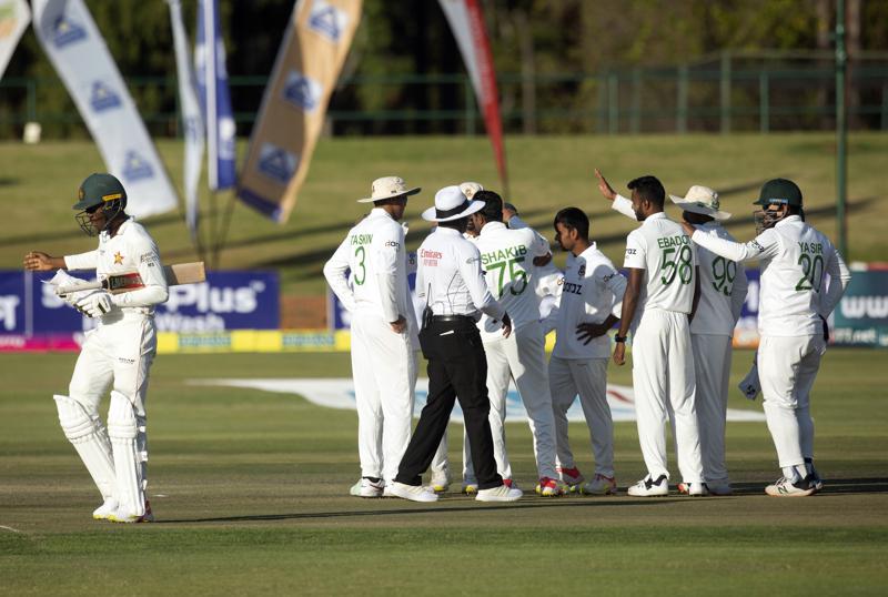 Zimbabwe batsman Milton Shumba,left, walks off the pitch after been dismissed on the second day of the test cricket match between Zimbabwe and Bangladesh at Harare Sports Club in Harare,Thursday, July,8, 2021.(AP Photo/Tsvangirayi Mukwazhi)