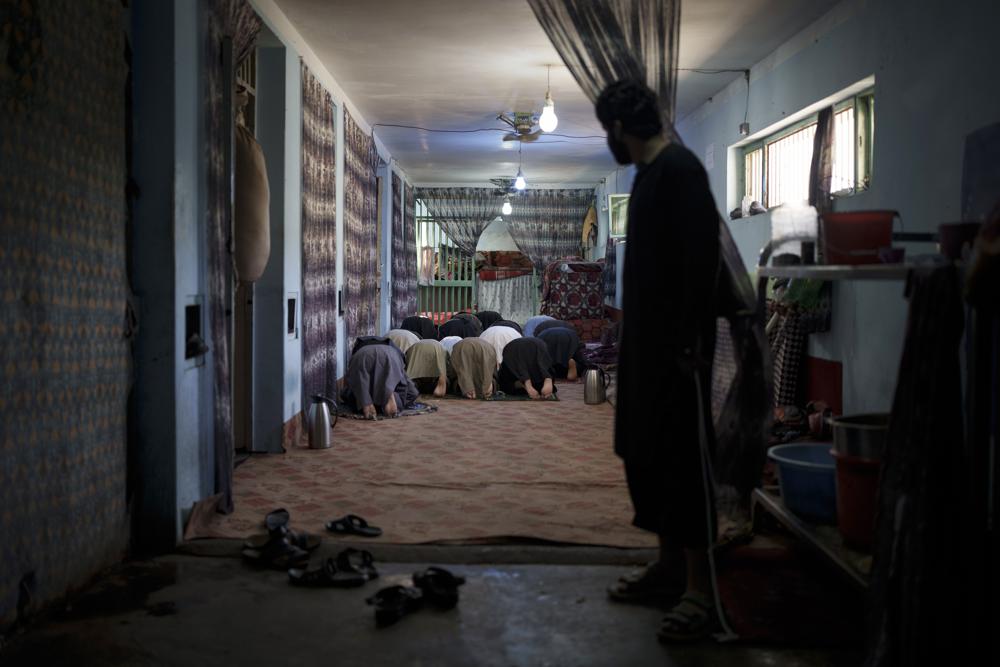 Un grupo de reclusos detenidos recientemente rezan en el penal de Pul-e-Charkhi, en Kabul, Afganistán, el 13 de septiembre de 2021. Pul-e-Charkhi era la principal prisión en la que el gobierno retenía a los talibanes capturados y era conocida por los abusos, las malas condiciones y el hacinamiento, con miles de reos entre sus muros. Ahora, tras hacerse con el control del país, el Talibán gestiona también el penal, que alberga a alrededor de 60 personas, en su mayoría drogadictos y delincuentes acusados. (AP Foto/Felipe Dana)