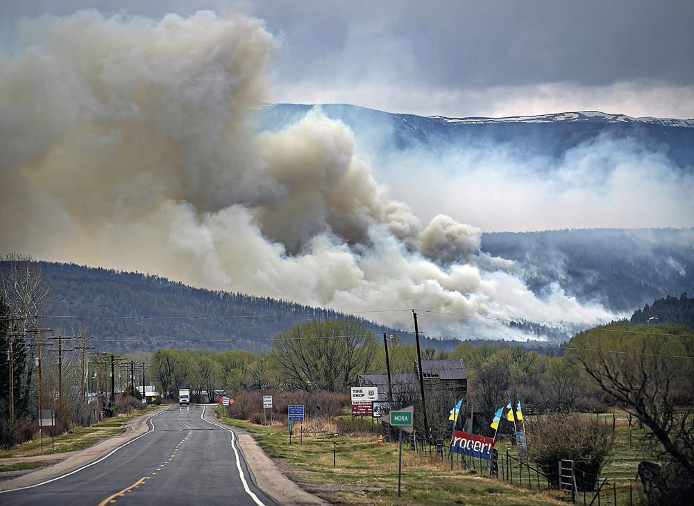 FILE - A flare up near Cleveland, just down 519 from Mora, N.M., darkens the sky on Wednesday, May 4, 2022, where firefighters have been battling the Hermit's Peak and Calf Canyon fire for weeks. New Mexico residents are suing the U.S. Forest Service for information on a massive wildfire that's been burning in the state since late April. The agency has been criticized for its role in causing two wildfires that merged to become the largest blaze in New Mexico history. (Jim Weber/Santa Fe New Mexican via AP, File)