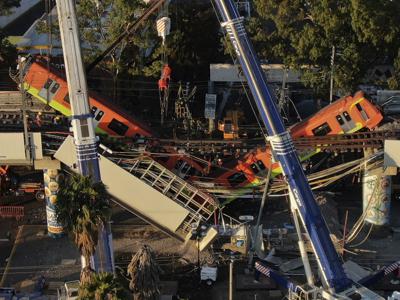 ARCHIVO - Los vagones del metro cuelgan en ángulo de una sección elevada colapsada de la línea Número 12 del metro, en la Ciudad de México, el martes 4 de mayo de 2021. Un juez ordenó el miércoles 20 de julio de 2022 que 8 exfuncionarios sean acusados ​​de homicidio en el derrumbe que dejó 26 muertos. (AP Foto/Fernando Llano, Archivo)