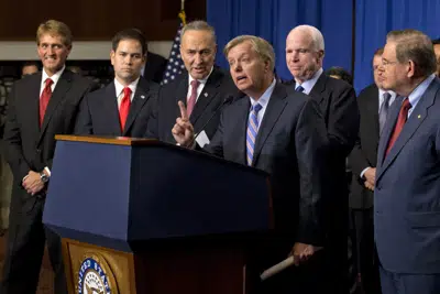 ARCHIVO - El senador republicano de Carolina del Sur Lindsey Graham, en el centro, habla sobre una iniciativa senadores de ambos partidos que habría abierto una vía a la ciudadanía para los 11 millones de inmigrantes sin permiso de residencia en el país, el 18 de abril de 2013 en el Capitolio, Washington. Desde la izquierda, el republicano de Arizona Jeff Flake, el republicano de Florida Marco Rubio, el republicano de Carolina del Sur Charles Schumer, Graham, el republicano de Arizona John McCain, el demócrata de Nueva Jersey Robert Menendez, y el líder de la mayoría en el Senado, el demócrata de Illinois Richard Durbin. (AP Foto/J. Scott Applewhite, Archivo)