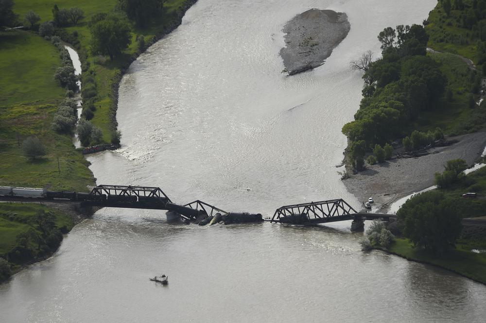 Portions of a freight train are seen in the Yellowstone River after an overnight railroad bridge collapse, near Columbus, Mont., Saturday, June 24, 2023. (Larry Mayer/The Billings Gazette via AP)
