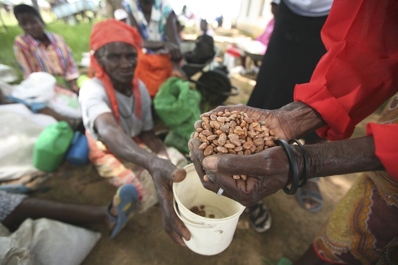 FILE - In this Thursday, Jan. 15, 2009 file photo, village women receive aid from the charity organisation, Oxfam International, at a distribution centre in Chirumhanzi about 250 Kilometers South east of Harare. The United Nations says about half of Zimbabwe’s population faces severe hunger amid a devastating drought and economic collapse. The World Food Program notes a “vicious cycle of skyrocketing malnutrition that’s hitting women and children hardest.” More than 7 million people overall are in need. (AP Photo/Tsvangirayi Mukwazhi, File)