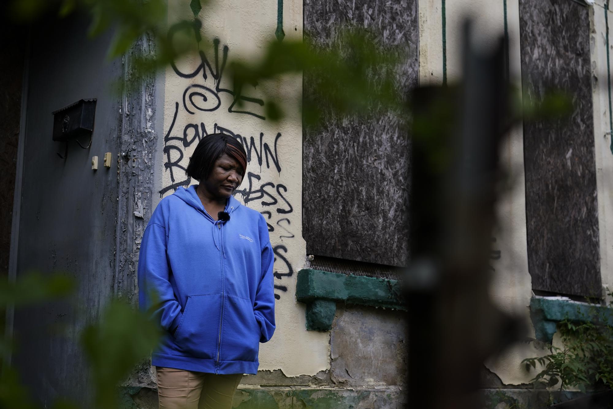 Pastor Marsha Hawkins-Hourd poses for a portrait outside a vacant building in St. Louis on Tuesday, May 18, 2021. She is part of a network of faith leaders and grassroots activists trying to overcome the distrust people have for the systems that typically address addiction but are infested with systemic racism, she said. She sees all the vacant buildings as a symbol of her neighbors who were deeply traumatized, then abandoned with limited access to treatment. (AP Photo/Brynn Anderson)