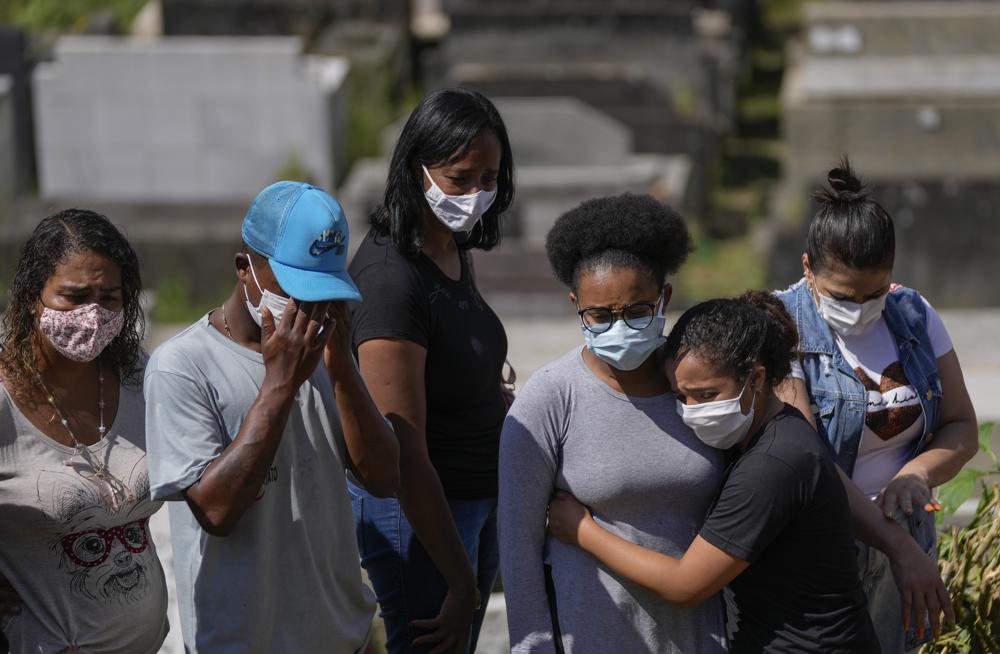 Los familiares de Zilmar Batista, de 54 años, quien murió en los deslizamientos de tierra, asisten a su entierro en el cementerio municipal de Petrópolis, Brasil, el jueves 17 de febrero de 2022. familias enterraban a sus muertos, no estaba claro cuántos cuerpos quedaron atrapados en el lodo.  (Foto AP/Silvia Izquierdo)