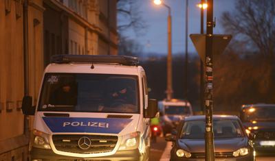 Una furgoneta de policía, en el distrito de Pieschen durante registros en una investigación por supuestas amenazas de muerte contra el gobernador del estado de Sajonia, en Dresde, Alemania, el 15 de diciembre de 2021. (Robert Michael/dpa via AP)