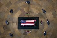 Officers salute the casket of former Sen. Harry Reid, D-Nev., as he lies in state in the Rotunda of the U.S. Capitol, Wednesday, Jan. 12, 2022, in Washington. Also pictured is Reid's hat, left at the casket by his wife, Landra Gould. (AP Photo/Andrew Harnik, Pool)