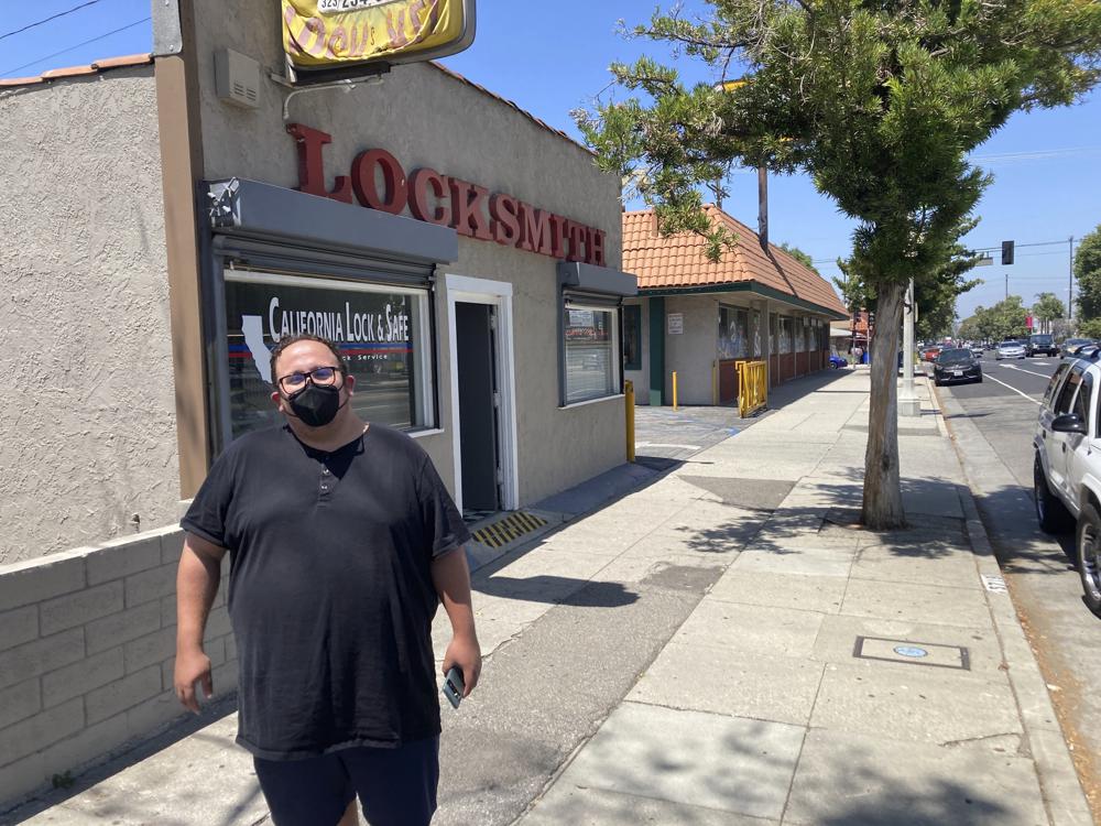 Nick Barragan wears a mask while running errands in Los Angeles on Wednesday, July 13, 2022. Los Angeles County is facing a return to a broad indoor mask requirement if current trends in hospital admissions continue, health officials said. Barragan said he's disappointed that the fast spread of COVID-19 could mean the return of a mandate, but he's used to wearing a mask because it's always been required for his job in film production. (AP Photo/Christopher Weber)