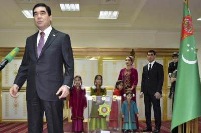 ARCHIVO - El presidente de Turkmenistán, Gurbanguly Berdimuhamedov, a la izquierda, habla con los periodistas después de emitir su voto mientras su hijo Serdar Berdymukhamedov, segundo a la derecha, con otros miembros de la familia mirando en un centro de votación en Ashgabat, Turkmenistán, el 12 de febrero de 2017. El pueblo de Turkmenistán votó el sábado 12 de marzo de 2022 en una votación destinada a sentar las bases de una dinastía política en la nación de Asia Central rica en gas. El presidente Gurbanguly Berdymukhamedov, de 64 años, anunció la votación el mes pasado, preparando el escenario para que su hijo Serdar, de 40 años, asuma el cargo. (AP Photo/Alexander Vershinin, Archivo)