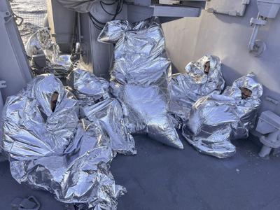 En esta foto distribuida por la Guardia Costera griega, algunos de los nueve sobrevivientes de un naufragio de migrantes, hallados en un islote deshabitado, se tapan con mantas térmicas en un buque guardacostas griego en el mar Egeo, Grecia, el martes 1 de noviembre de 2022. (Guardia Costera griega vía AP)