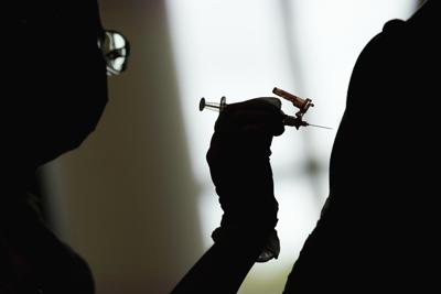 Esta fotografía de archivo del 26 de abril de 2021 muestra a un estudiante de enfermería aplicando la vacuna de Moderna contra el COVID-19 en un centro de inoculación de la Universidad de Nevada, en Las Vegas. (AP Foto/John Locher, archivo)