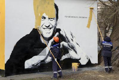 Trabajadores municipales pintan sobre una imagen del encarcelado líder opositor ruso Alexei Navalny en San Petersburgo, Rusia, el 28 de abril de 2021. (AP Foto/Valentin Egorshin, archivo)